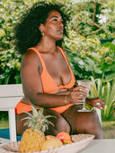 femme portant un maillot de bain orange assise