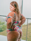 Femme de dos portant un bikini à voilage imprimé tropical