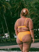 femme de dos portant un maillot deux-pièces debout sur une plage