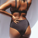 femme porte un bas de maillot noir brillant 