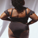femme portant un maillot de bain deux pièces noir satiné 